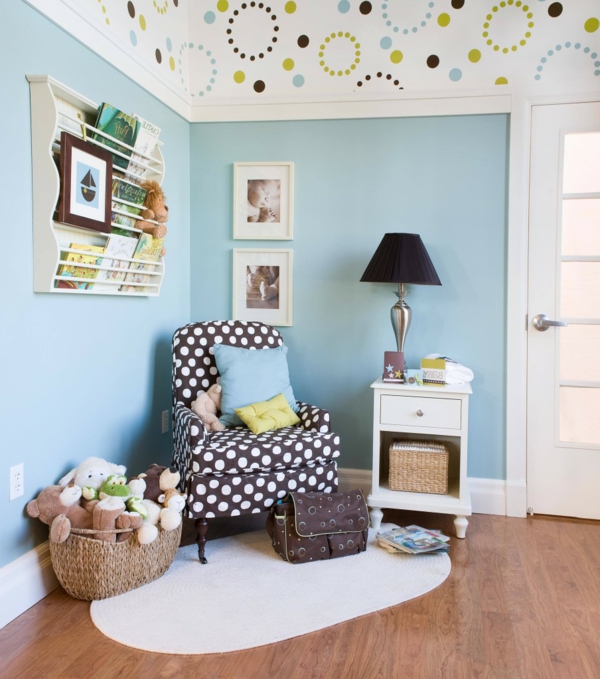 babyzimmer-tapeten-blau- plüschtiere und ein sessel mit dekokissen darauf