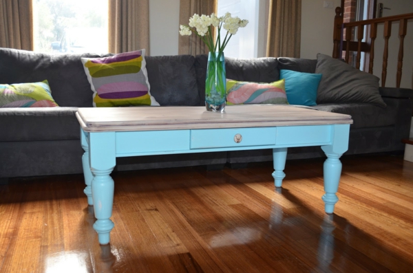 retro-couchtisch-blaue-farbe - neben einem grauen sofa