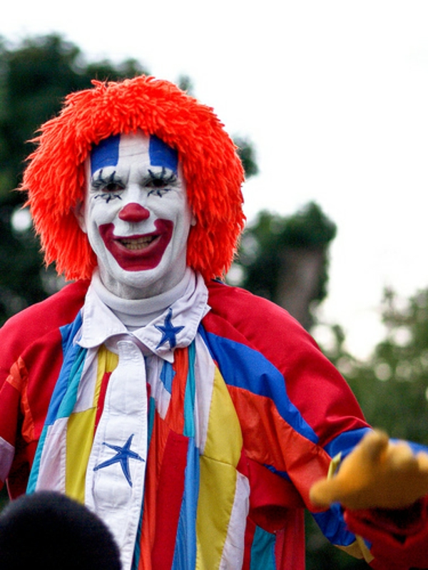 clownschminken - lustiges aussehen eines mannes - mit einer orange perücke
