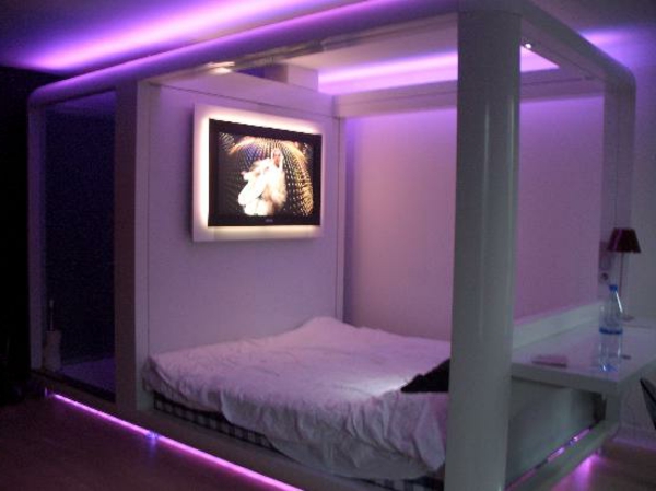 kleines schlafzimmer mit einer lila beleuchtung
