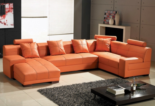 wohnzimmer-einrichten-ledercouch-design--in-orange-sofa-mit-schlaffunktion