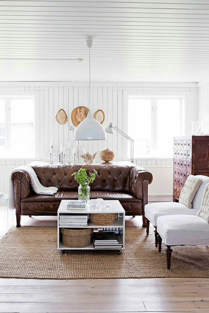 weißes-Wohnzimmer-Rattan-Teppich-Strohhüte-Chesterfield-Sofa-weiße-Sessel