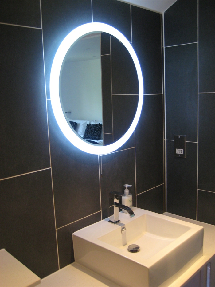 elegantes-Badezimmer-Interieur-schwarze-Fliesen-spiegel-mit-led-beleuchtung-ovale-Form