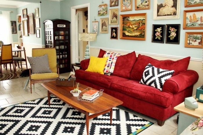 artistisches-Wohnzimmer-schöne-Wandbilder-graphischer-Teppich-Kissen-rotes-Sofa