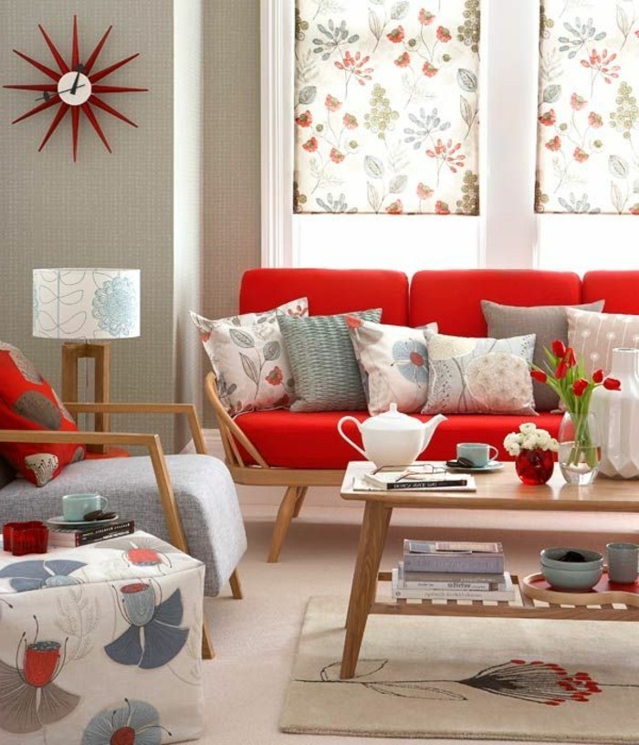 moderne-Ausstattung-Muster-mit-floralen-Motiven-hölzerner-Kaffeetisch-rote-Tulpen-interessante-Wanduhr-rote-Couch