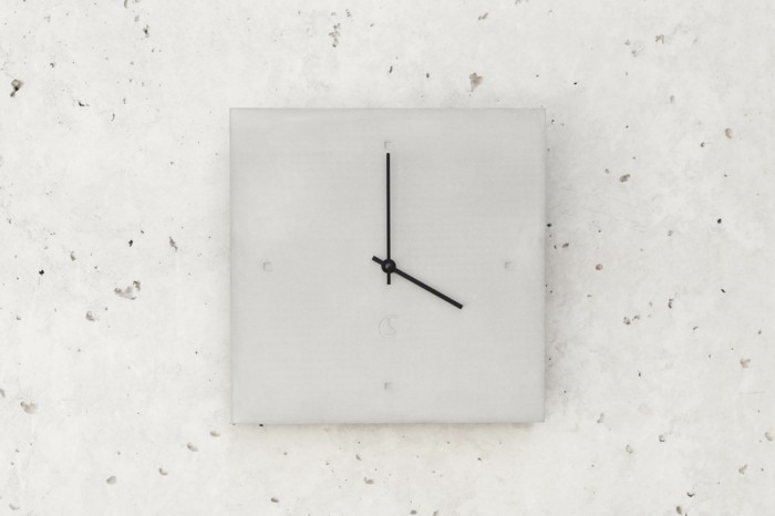 c-clock-no-1-graue-wanduhr-mit-schwarzen-zeigern-auf-beton
