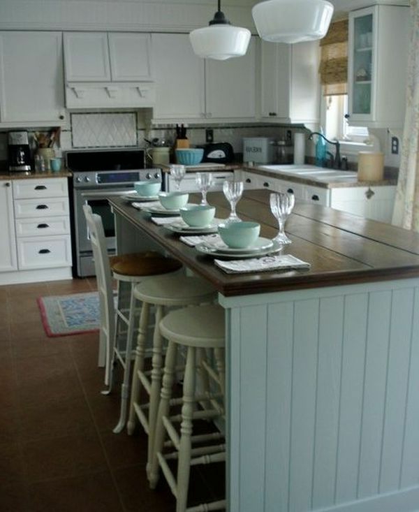 Weiße Kronleuchter und Kochinsel aus Holz für ein schlichtes und schönes Küchendesign