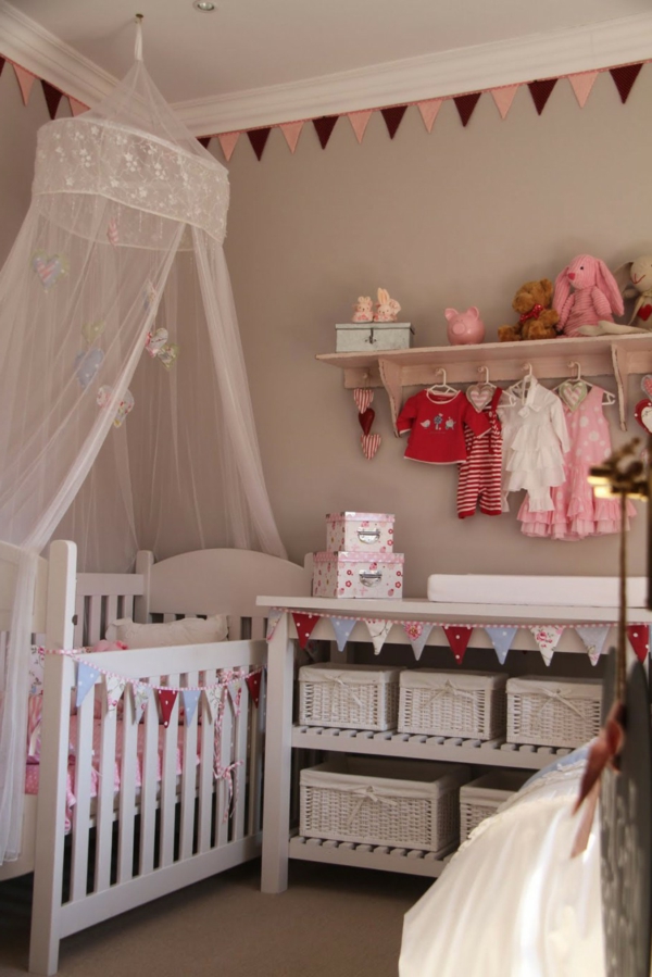 kleider hänger bett mit durchsichtigen vorhängen im babyzimmer