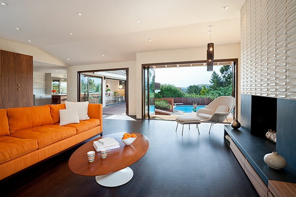 wohnzimmmer mit einem orangen couch und draußen - pool