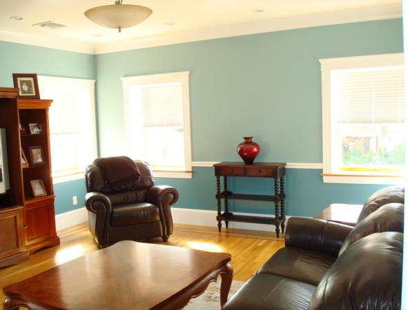 kleines wohnzimmer mit modernen möbeln und schöner wandgestaltung in blau