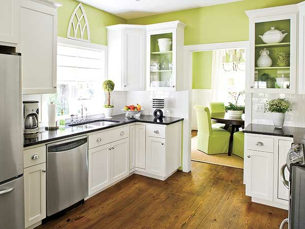 grüne wände weiße schränke und metallische elemente in der küche
