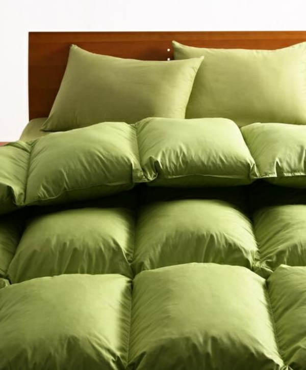 schlafzimmer mit grünen bettbezügen und kissen