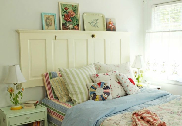schlaffzimmer mit einem bett mit weißen und bunten bettbezügen und kissen