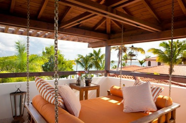 hängendes bett in orange auf einer modernen hölzernen terrasse mit schönem blick
