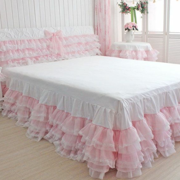 zärtliche atmosphäre im schlafzimmer mit einem bett mit weißen und rosigen bettbezügen