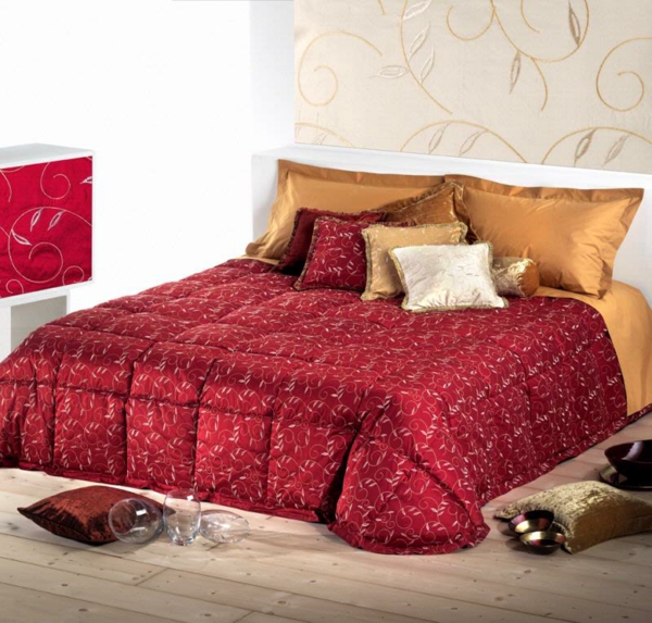 schlafzimmer mit einem bett mit bettbezügen und kissen in roten und goldenen farben