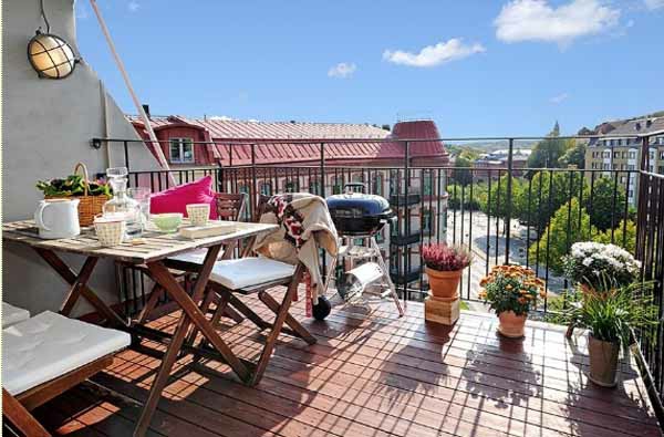 terrasse mit schöner gestaltung - blumen und hölzernem tisch