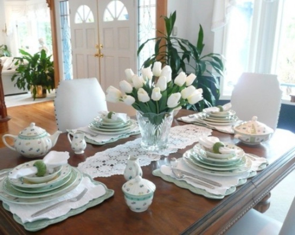 tisch im luxus esszimmer - mit weißen tulpen und porzellangeschirr ausstattten