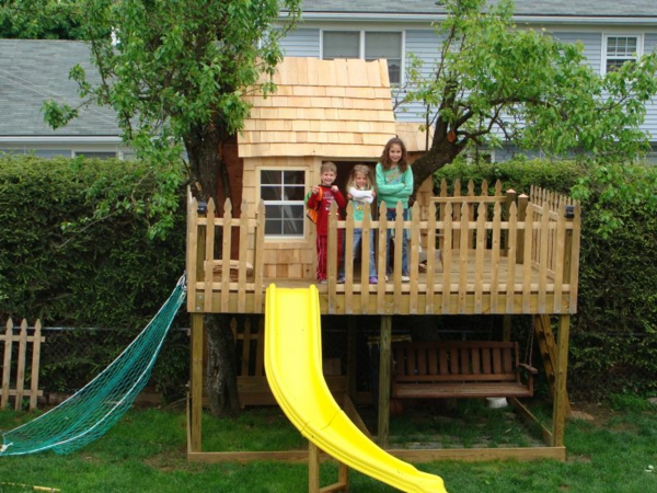 baumhaus-für-kinder-mit-einer-rutsche- in gelber farbe