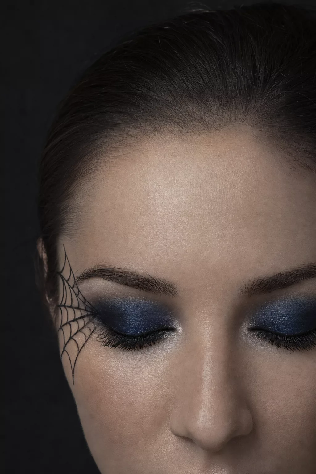 Nahaufnahme Spinnennetz-Augen-Make-up in Schwarz und Blau