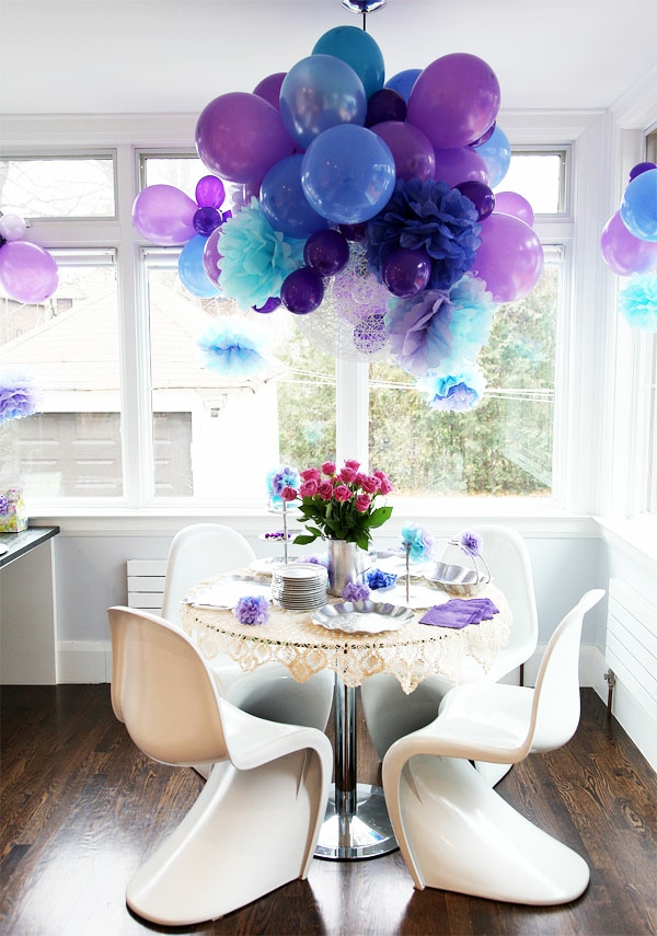ballons hängen von der decke als dekoration im kleinen zimmer - blau und lila