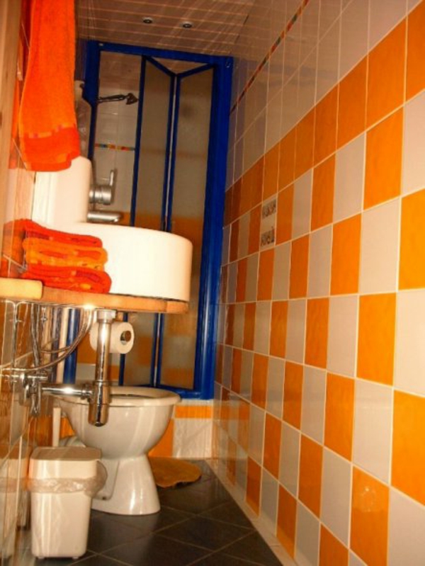 toilette-orange-und-weiße-fliesen- klein und gemütlich