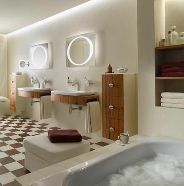 zwei runde spigel mit leuchten an der wand im luxus badezimmer mit einer badewanne