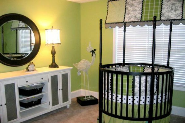 babyzimmer-gestalten-grünewandfarbe -rundes-babybett - spiegel und lampe