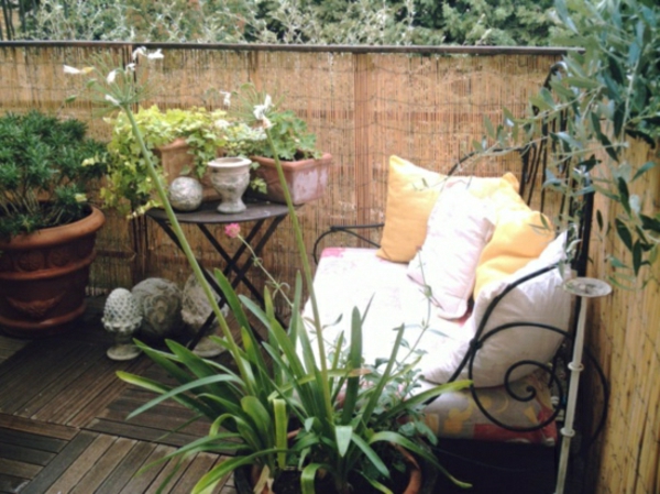 balkon-sichschutz-bambus-grüne-pflanzen-dekorative-kissen-auf-dem-sofa