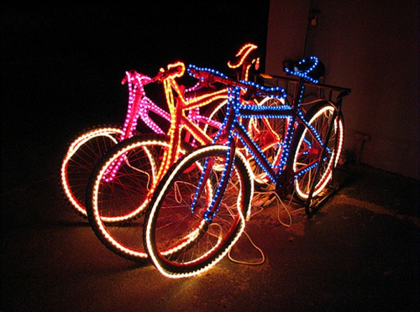 drei-fahrräder-mit-led-beleuchtung-deko-idee im zimmer, das dunkel ist