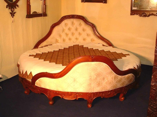 aristokratisch-aussehendes-bett-mit-runder-form-in der ecke des schlafzimmers