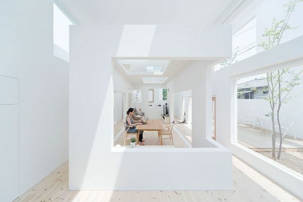 atemberaubende-minimalistische-architektur-in-weiß- eine sitzende frau