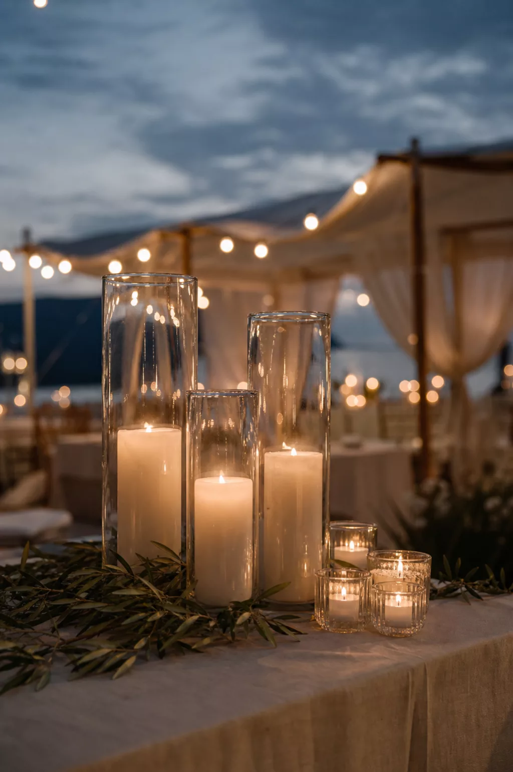 Hohe Windlichter und Teelichter sorgen für warme Abendstimmung am Tisch