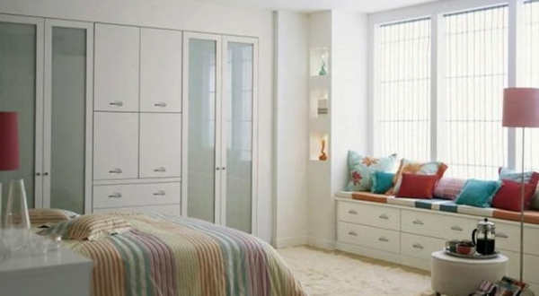 moderne-schlafzimmermöbel-in-weiß-viele bunte dekokissen