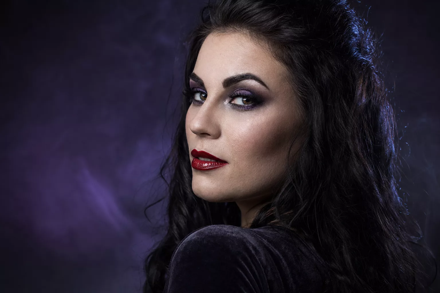 Vampir schminken modern: glänzende rote Lippen, schimmernde dunkle Augen