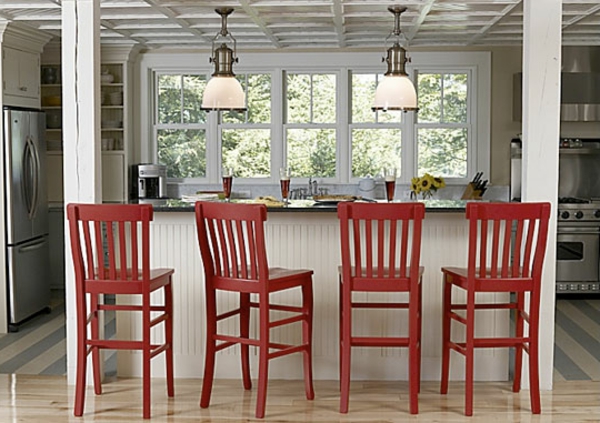 vier-schöne-rote-barhocker-in einer küche mit weißer farbgestaltung