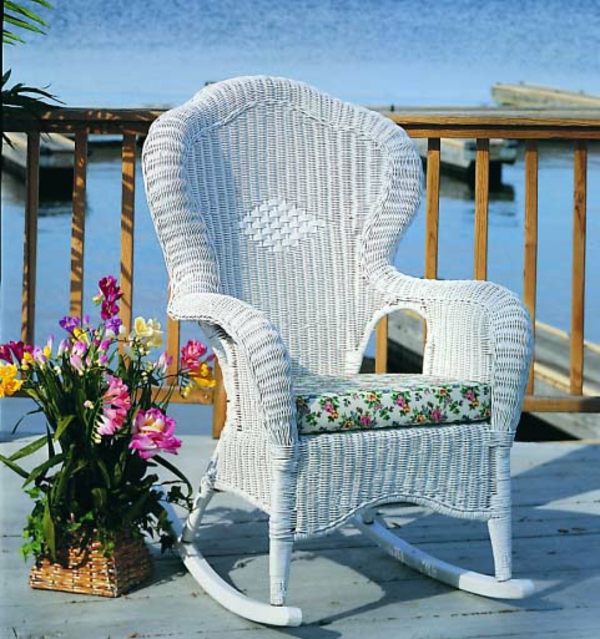 weißer-schaukelstuhl-aus-rattan-draußen-auf der terrasse
