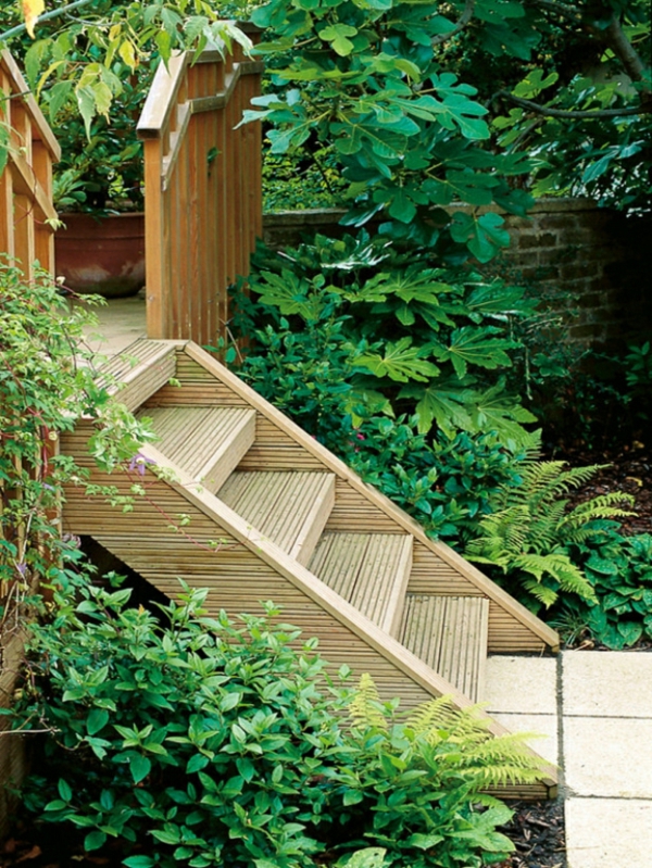 Holztreppe-bauen-im-garten-kieswege-gestalten- umgebung von grünen pflanzen