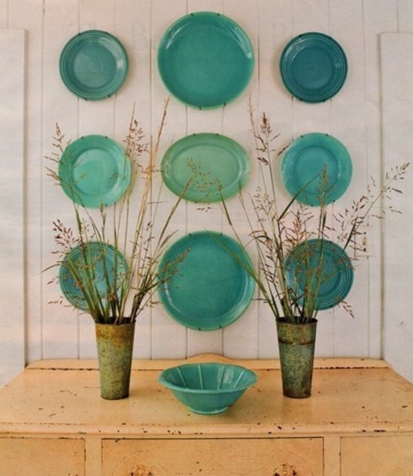 Küchenwandgestaltung-mit-sechs-grüne-teller-verschiedener-große-und-trockene-pflanzen