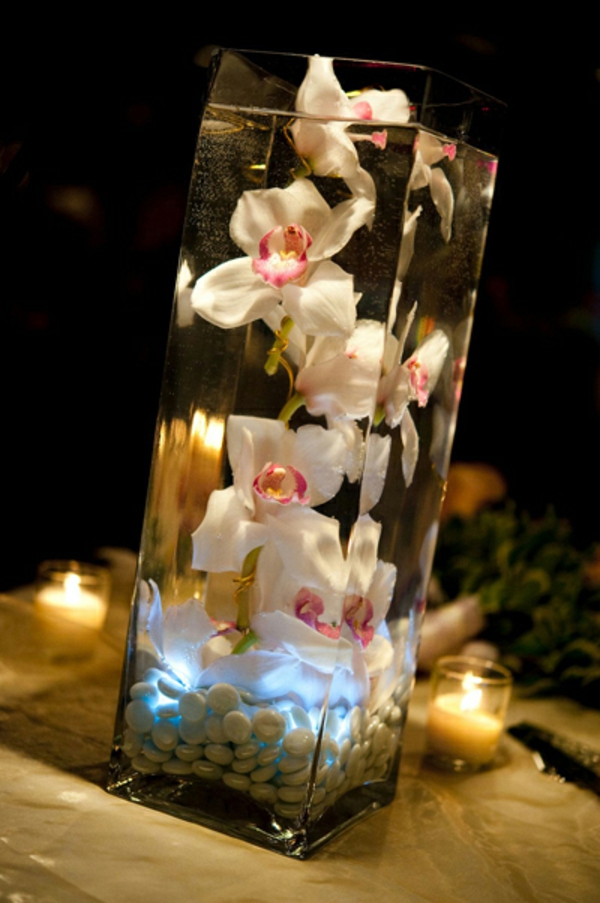 deko-mit-orchideen-im-gläsernen-becher-kleine kerzen daneben