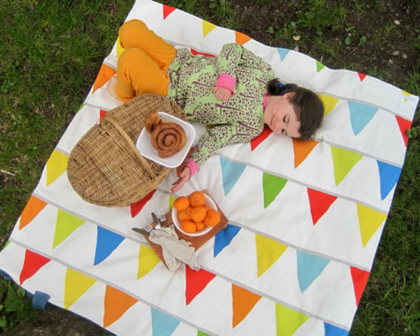 ein-mädchen-liegt-auf-einer-picknick-decke- foto von oben genommen