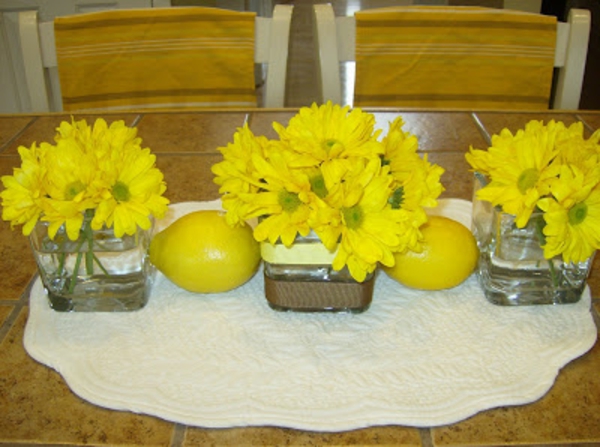 gelbe-blumen-und-gelbe-zitronen-dekoration- auf einer weißen decke