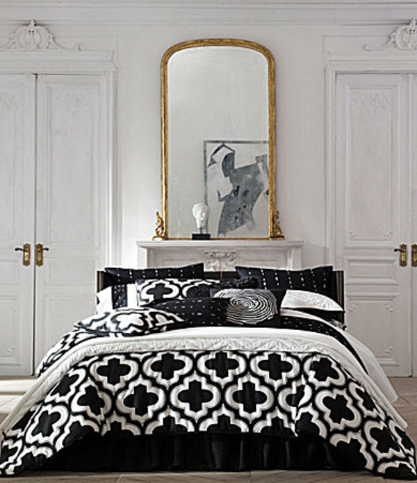 moderne-schwarze-bettwäsche-mit-weißen-elementen- und einem riesigen spiegel