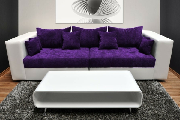 modernes-weißes-lila-sofa-mit-sofakissen-in-lila-farbe- ein großes bild an der wand