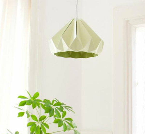 origami-lampenschirm-im-grün-und-die-pflanze-neben-der-weisse-wand