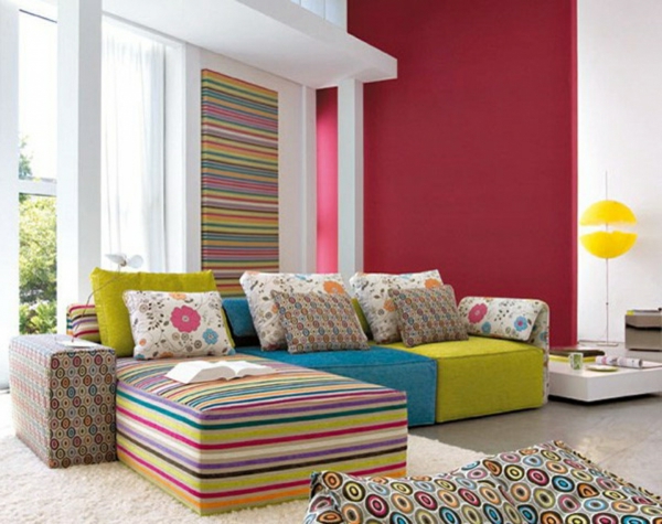 schicke-rote-akzentwant-sofa-auf-bunten-streifen-weiße-wände