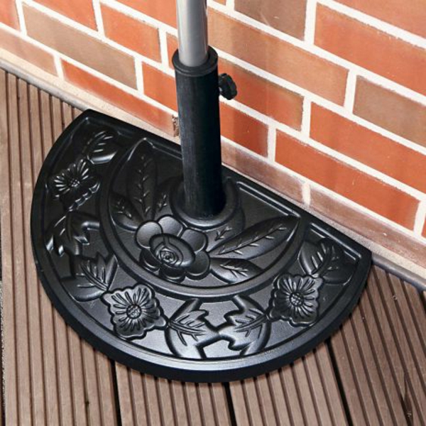 schwarzer-moderner-sonnenschirmständer- für-balkon-eine ziegelwand daneben