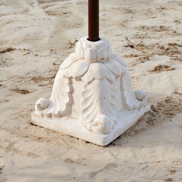 weißer-sonnenschirmständer- für-balkon-auf dem sand stehend