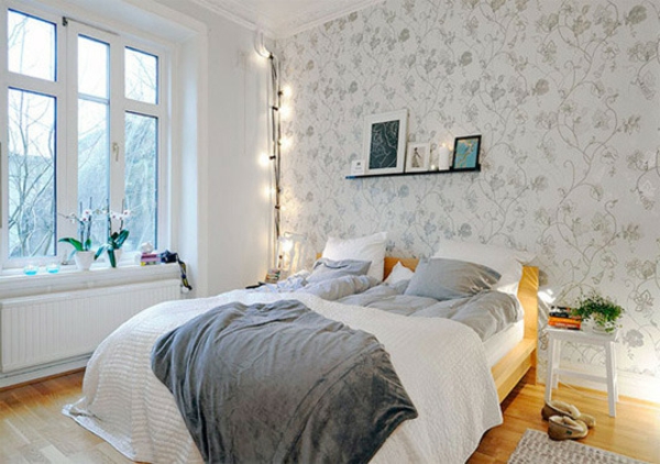 weißes-schlafzimmer-mit-einem-skandinavischen-bett-interessante beleuchtung in der ecke des zimmers