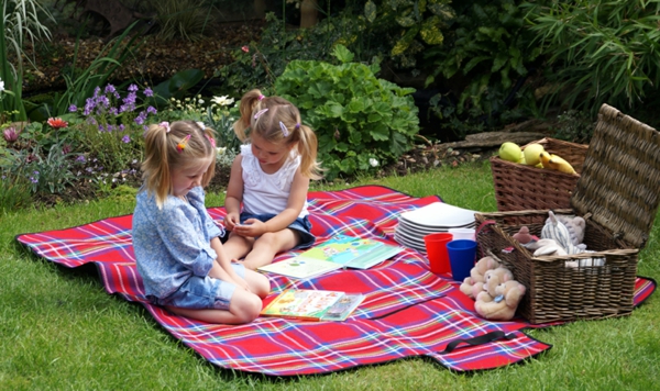 zwei-kleine-mädchen-auf-einer-picknick-decke- sie unterhalten sich